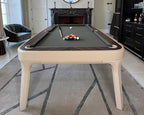 Luxury Dandy pool table in ivory leather with grey cloth in a classic living room with a fireplace