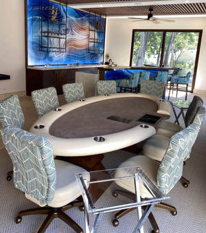 Luxury ellipse poker table with white leather rail, grey cloth, dealer cut-out and steel cupholders in a home bar