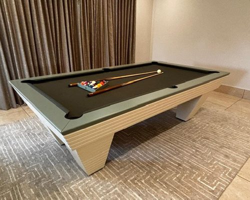 Angled view of the Luxury Newde with sage grey top rail, dark cloth and cream ribbed legs