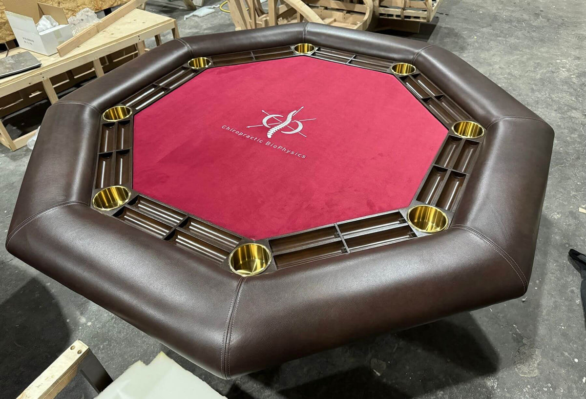Luxury octagonal poker table with red playing surface, hardwood racetrack and brass cupholders
