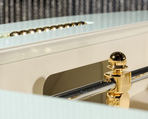 Close-up of a gold player and chrome rod on a cream Luxury Oskar football table