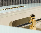 Close-up of a gold player and chrome rod on a cream Luxury Oskar football table