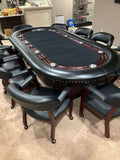 Luxury 96 x 48 inch oval poker table seating 10, with black playing surface, hardwood racetrack and leather chairs