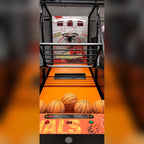 Basketball arcade machine lit up in a dark room