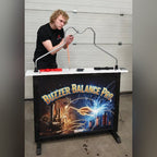 A man playing the MadeForArcade Buzzer Balance Pro buzz wire game at an exhibition stand