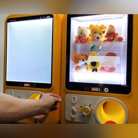Yellow MadeForArcade capsule vending machine with a lit display window