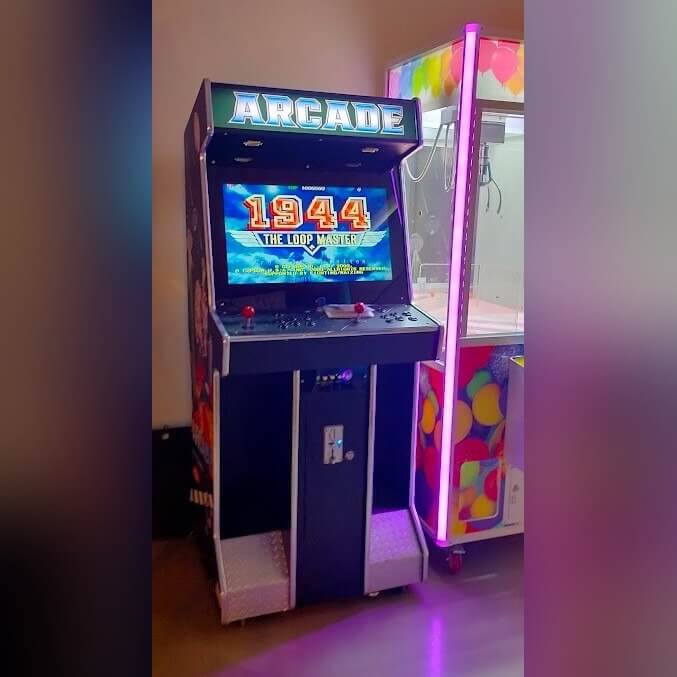 Full-size arcade machine glowing in a dark room