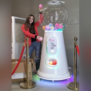 A woman using the giant white gumball machine at an event