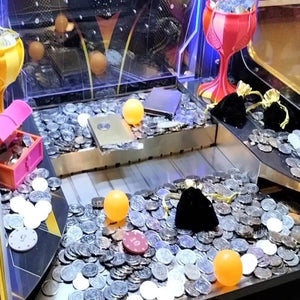 Coins and prizes piled on the coin pusher playfield