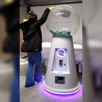 A woman using the MEGA gumball machine with purple neon lighting