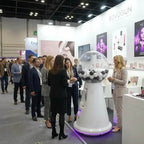 Crowd around a MEGA gumball machine at an exhibition