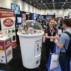 Giant milkshake cup capsule machine at a busy exhibition