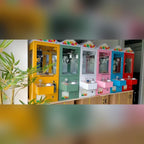 Row of colourful mini claw machines on a counter