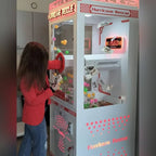 A girl reaching into the money grabber