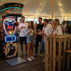 Crowd watching a player at the MadeForArcade Pro Boxing Machine at an outdoor festival