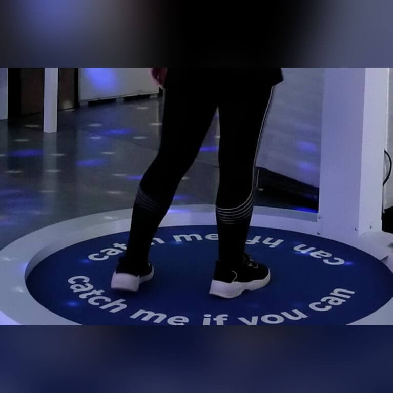 Player's feet on a printed Catch Me If You Can centre carpet inside the Reaction Ring