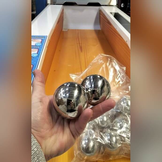 Hand holding two skee-ball balls