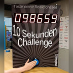 A hand pressing the button on the 10 Sekunden Challenge wall unit