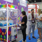 People playing themed claw machines at an event