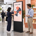 Visitors gathered at a prize wheel kiosk