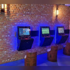 Three wall-mounted arcade machines with backlighting