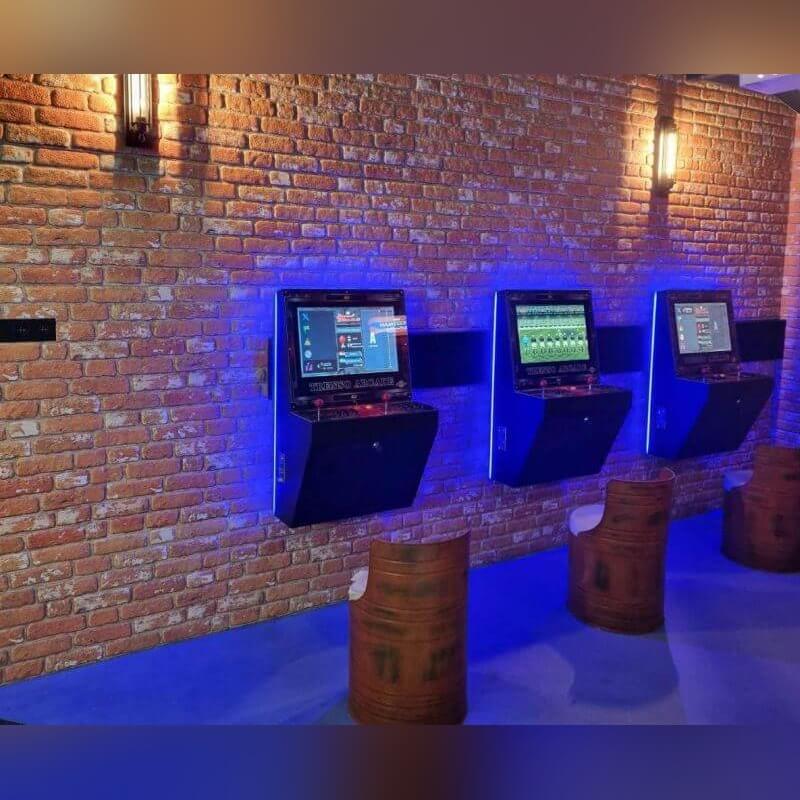 Wall-mounted arcade machine on a brick wall