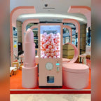 Pink XXL capsule vending tower with a branded wrap in a shop