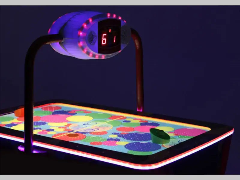 Close-up of the SAM Baby Evo overhead scorer and bright spotted playfield in the dark