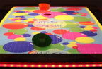 Colourful spotted methacrylate playfield of the SAM Baby Evo with puck and bat
