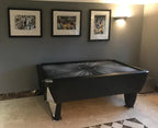 SAM Black Ice II air hockey table in a home with framed pictures on the wall