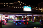 SAM Fast Track Evo II air hockey tables in an outdoor amusement venue at night