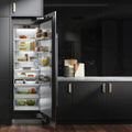 Signature Kitchen Suite integrated larder fridge open in a black kitchen, showing fresh food on lit shelves