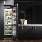 Signature Kitchen Suite integrated larder fridge open in a black kitchen, showing fresh food on lit shelves