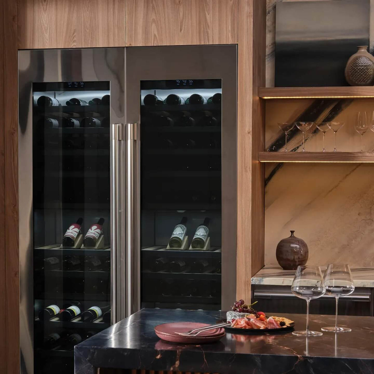 Two Signature Kitchen Suite integrated wine fridges side by side in a wood-panelled kitchen with wine glasses on the counter