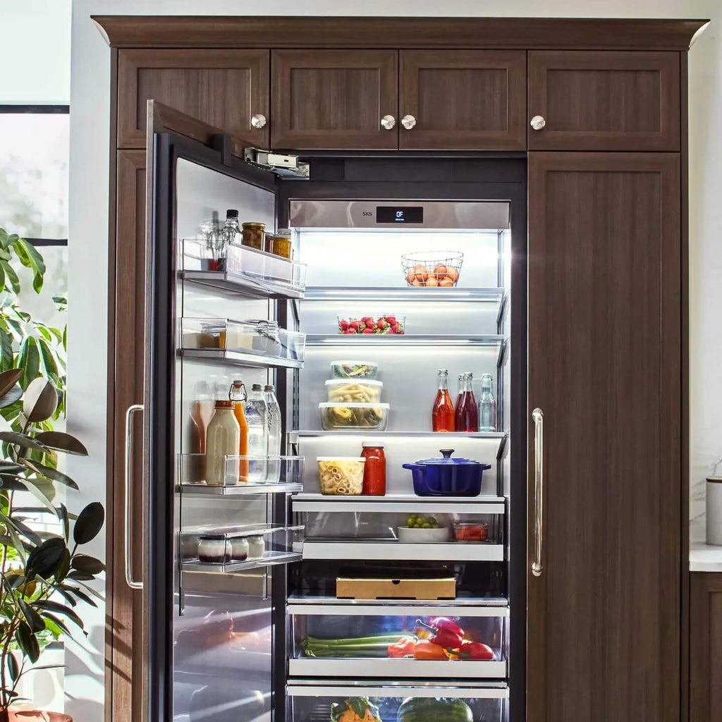 Signature Kitchen Suite integrated larder fridge open in a wood-panelled kitchen, filled with fresh food and drinks