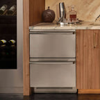 Signature Kitchen Suite stainless steel fridge drawers built under a marble bar counter beside a wine fridge