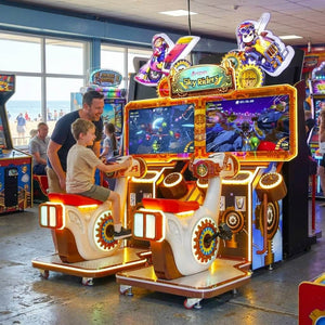 Sky Riders twin ride-on arcade machine in a UK seaside arcade with a child playing while a parent watches
