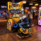 Teenager leaning into a corner on Storm Rider at a bowling alley in the evening