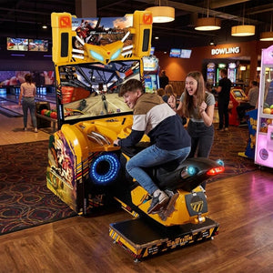 Teenager leaning into a corner on Storm Rider at a bowling alley in the evening