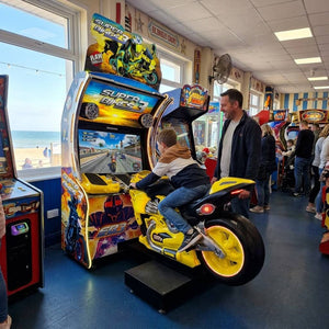 Super Bikes 3 motorbike racing arcade machine in a UK seaside arcade with a child riding