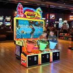 Three children playing Super Drill at a bowling alley in the evening