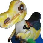 Close-up of the yellow dinosaur figure with black saddle and reins