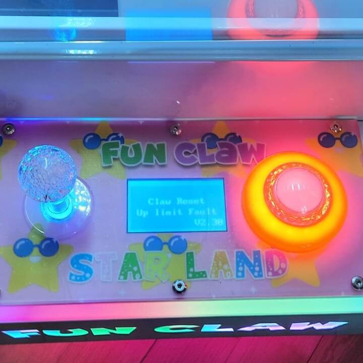 Close-up of the WIK Fun Claw control panel with joystick, lit button and display