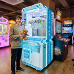 Smiling teenager holding a teddy bear won from the WIK Space Drop in a family entertainment centre
