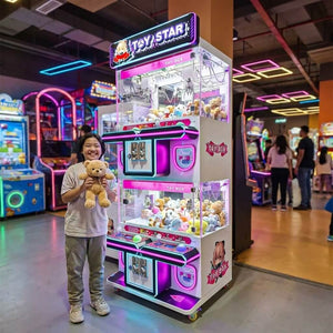 Smiling teenager holding a teddy bear won from the WIK Toy Star Mini 4 player in a family entertainment centre