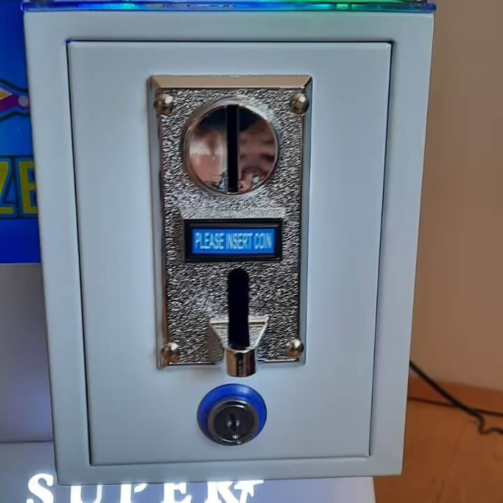 Coin acceptor on the front of the WIK Toy Star Mini claw machine with insert coin display