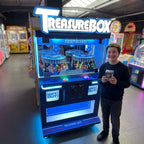 Smiling teenager holding a small boxed prize won from the WIK Treasure Box Clip in a family entertainment centre