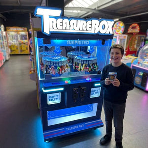 Smiling teenager holding a small boxed prize won from the WIK Treasure Box Clip in a family entertainment centre
