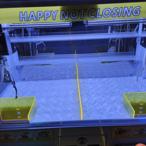 Inside one level of the WIK Trend Star claw machine showing two claws and two prize drop chutes