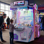 Boy playing the WIK Tri-Grab 3 claw crane machine while his dad watches in a seaside amusement arcade